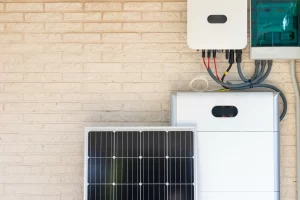 Bateria all in one UCB UniPower Slim instalada em parede com módulos fotovoltaicos e cabos de conexão organizados, indicada para integradores e integração do sistema.