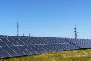 Painel de energia solar em fazenda fotovoltaica com torres de transmissão ao fundo, mostrando integração de geração distribuída e o contexto da MP 1.304 no setor elétrico, impactos e oportunidades.