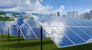 Campo com painéis solares fotovoltaicos instalados em fileiras, com cidade ao fundo, ilustrando normas e regulamentação Grid Zero e o processo de homologação para geração distribuída