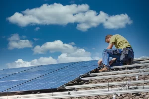 Técnico instala placas solares em telhado com céu azul e nuvens, ilustrando como o sistema fotovoltaico gera energia sem exportação na proposta Zero export.